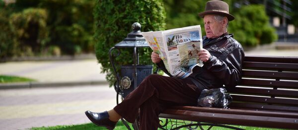 Мужчина читает газету на лавочке  - Sputnik Беларусь