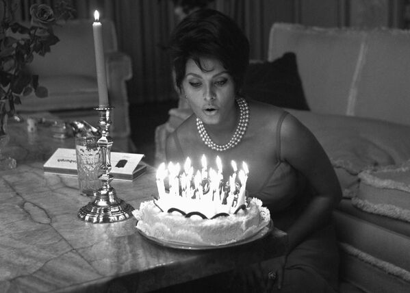 Итальянская актриса готовится задуть свечи на торте в день 27-летия в своем доме в Риме. - Sputnik Беларусь