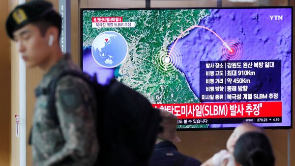 Солдат Южной Кореи проходит мимо телевизора, транслирующего репортаж о Северной Корее, которая выпустила ракету - Sputnik Беларусь