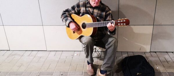 Пенсионер Владимир Гайденко играет на гитаре в переходе - Sputnik Беларусь