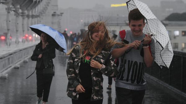 Молодые люди идут под зонтом - Sputnik Беларусь
