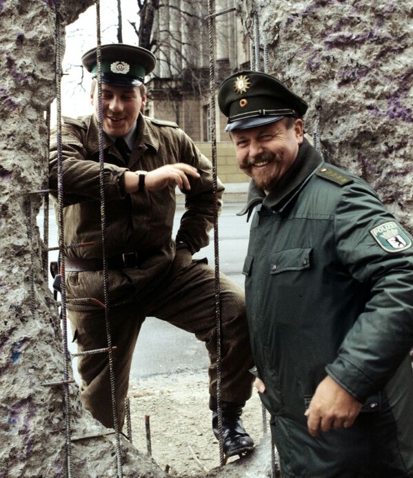 Пограничники Германской Демократической Республики (ГДР) и Федеративной Республики Германия (ФРГ) у Берлинской стены в феврале 1990-го.  - Sputnik Беларусь