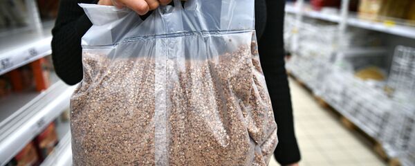 Пакупніца нясе пакет з грачанымі крупамі Пакупніца нясе пакет з грачанымі крупамі - Sputnik Беларусь