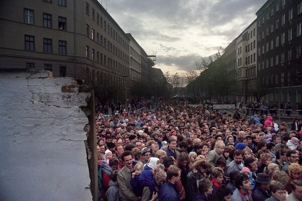 Тысячи жителей Восточного Берлина собрались 11 ноября 1989 года в одном из новых проемов, созданных бульдозерами, на Эберсвальде-штрассе, чтобы посетить Западный Берлин, совершить покупки. - Sputnik Беларусь