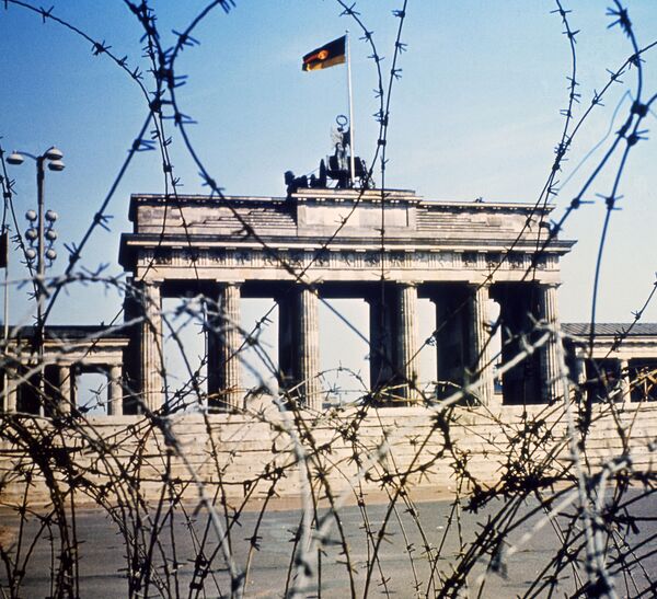 Бранденбургские ворота видны через забор из колючей проволоки в июне 1968 года. Бетонная стена с колючей проволокой на долгие годы стала символом конфронтации между двумя блоками государств, центром одного из которых был СССР, а другого – США. - Sputnik Беларусь