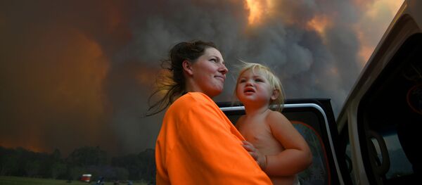 Шарни Морен и ее 18-месячная дочь Шарлотта смотрят, как густой дым поднимается от лесных пожаров недалеко от Кофс Харбора Шарни Морен и ее 18-месячная дочь Шарлотта смотрят, как густой дым поднимается от лесных пожаров недалеко от Кофс Харбора - Sputnik Беларусь