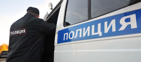 Сотрудник полиции Управления министерства внутренних дел Российской Федерации у служебного автомобиля - Sputnik Беларусь