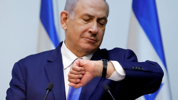 Израильский премьер - министр Биньямин Нетаньяху смотрит на часы перед утверждением закона в Кнессете - Sputnik Беларусь