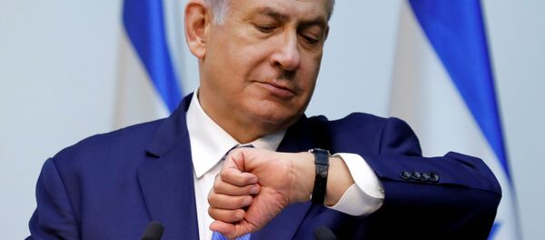 Израильский премьер - министр Биньямин Нетаньяху смотрит на часы перед утверждением закона в Кнессете - Sputnik Беларусь