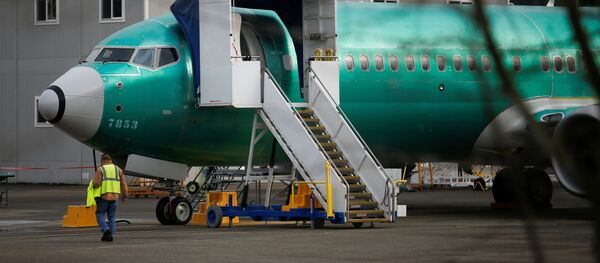 Рабочий проходит мимо самолета Boeing 737 Max, припаркованного у производства предприятия Boeing - Sputnik Беларусь