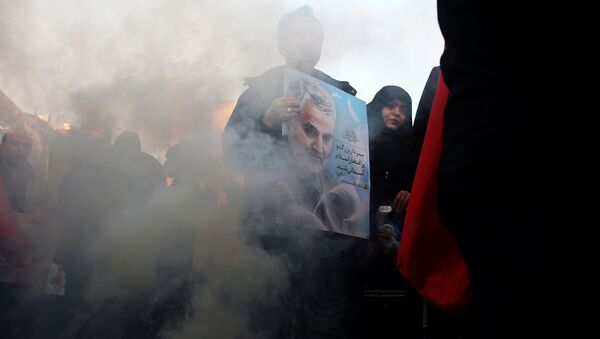 Иранец держит в руках портрет генерала Сулеймани - Sputnik Беларусь