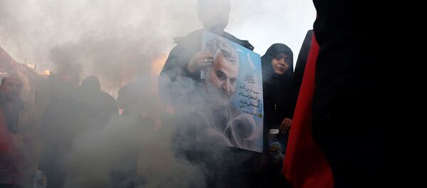 Иранец держит в руках портрет генерала Сулеймани - Sputnik Беларусь