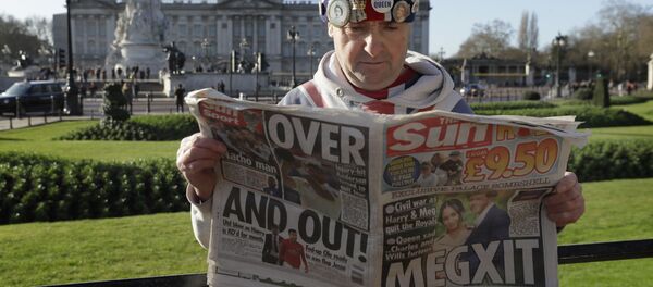 Королевский фанат Джон Лафри позирует с газетой перед Букингемским дворцом в Лондоне - Sputnik Беларусь