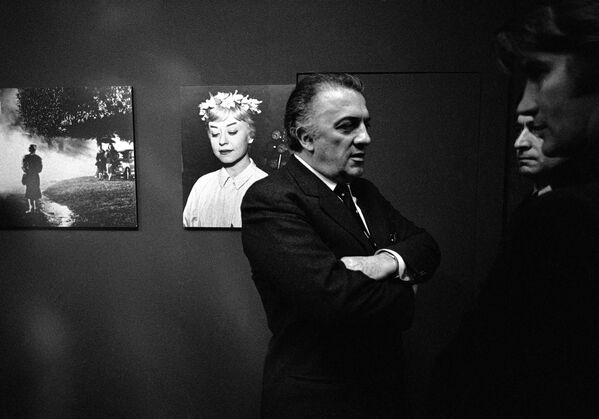 Итальянский кинорежиссер Федерико Феллини перед портретом своей жены итальянской актрисы Джульетты Мазины на открытии выставки фотографий из фильма Ночи Кабирии в Мюнхене 29 февраля 1970 года. - Sputnik Беларусь