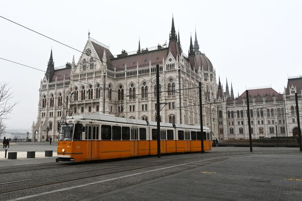 Здание венгерского парламента и будапештский трамвайчик. Трамваи бегают по городу с 1866 года, а сеть является сегодня одной из крупнейших в мире, имея протяженность в 157 километров.  - Sputnik Беларусь