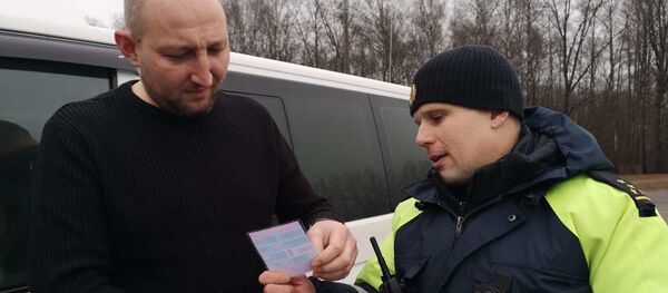 Инспектор вручает водителю листовку - Sputnik Беларусь