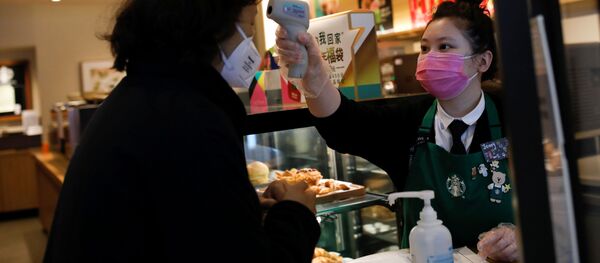 Работница использует термометр для проверки температуры клиента - Sputnik Беларусь