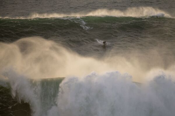 Бразильский серфер на гигантских волнах во время турнира Nazare Tow Surfing Challenge в Португалии  - Sputnik Беларусь