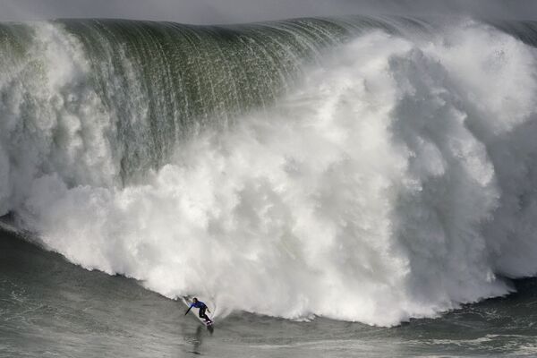Гавайский серфер на гигантских волнах во время турнира Nazare Tow Surfing Challenge в Португалии  - Sputnik Беларусь