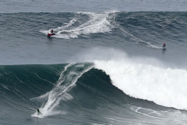 Серферы на гигантских волнах во время турнира Nazare Tow Surfing Challenge в Португалии  - Sputnik Беларусь