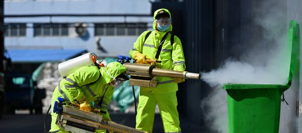 Волонтеры в защитных костюмах проводят дезинфекцию Волонтеры в защитных костюмах проводят дезинфекцию - Sputnik Беларусь