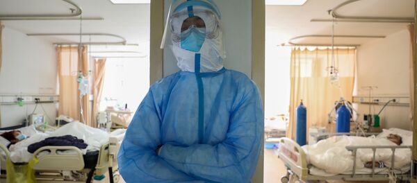Медицинский работник в защитном костюме в отделении Уханьской больницы - Sputnik Беларусь