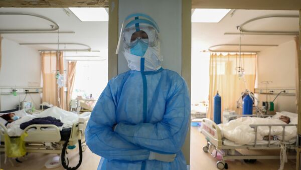 Медицинский работник в защитном костюме в отделении Уханьской больницы - Sputnik Беларусь