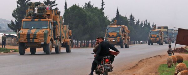 Сирийцы ждут, чтобы пересечь перекресток, поскольку турецкий военный конвой проезжает мимо деревни Кафр-Ямул, к северу от Идлиба на северо-западе Сирии,  - Sputnik Беларусь