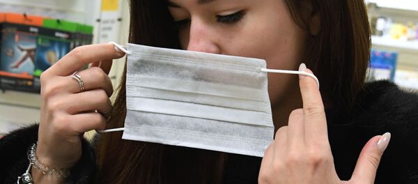Девушка надевает защитную маску Девушка надевает защитную маску - Sputnik Беларусь