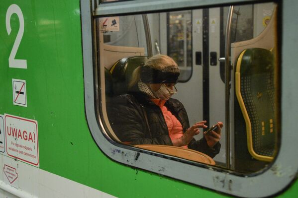 Женщина в медицинской маске в общественном транспорте Варшавы - Sputnik Беларусь