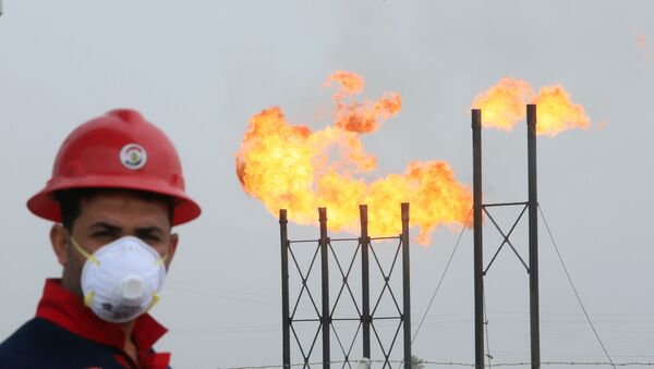Мужчина в защитной маске на фоне факельных труб на нефтяном месторождении Нар Бин Умар - Sputnik Беларусь