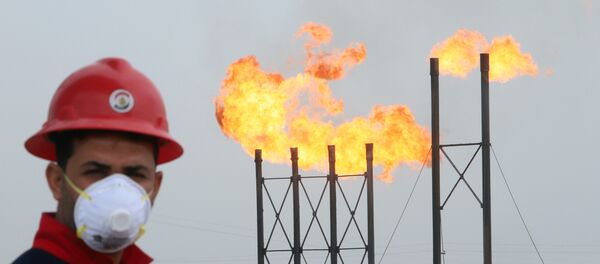 Мужчина в защитной маске на фоне факельных труб на нефтяном месторождении Нар Бин Умар - Sputnik Беларусь