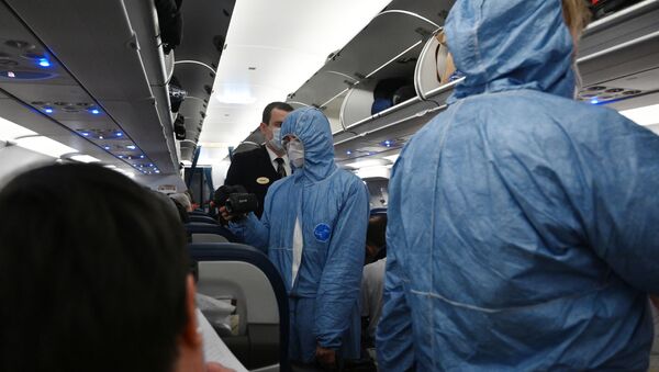 Сотрудники Роспотребнадзора проверяют тепловизором температуру у пассажиров на борту самолета - Sputnik Беларусь