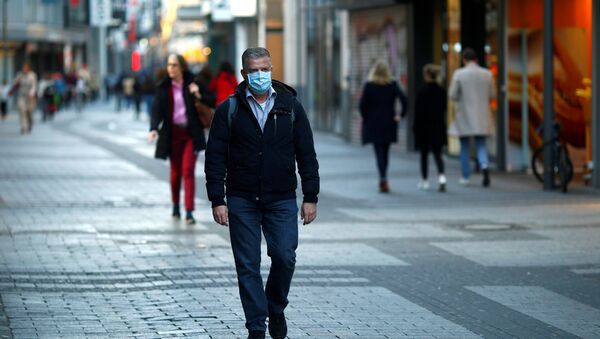 Мужчина идет в маске по улице - Sputnik Беларусь
