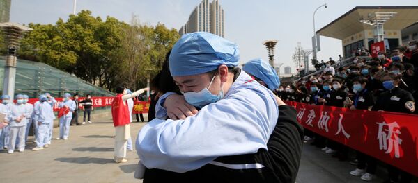 Медицинский работник из города Ухань прощается с коллегой из Цзяньсу - Sputnik Беларусь