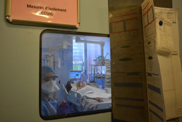 Медсестра во время лечения пациента с COVID-19 в отделении интенсивной терапии в больнице Биша на севере Парижа - Sputnik Беларусь
