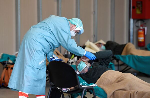 Врач помогает пациенту во временной больнице в Брешиа, Италия - Sputnik Беларусь