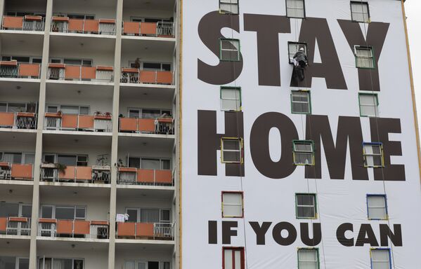 Рекламный плакат с призывом остаться дома на здании в Южной Африке  - Sputnik Беларусь