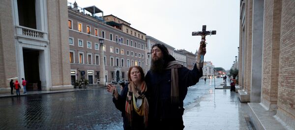 Два человека молятся рядом с Ватиканом, когда папа Франциск произносит необычайное благословение Урби и Орби в Риме - Sputnik Беларусь