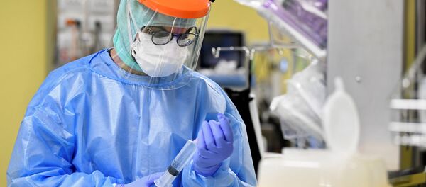 Медык у ахоўным касцюме лечыць пацыента з COVID-19 у аддзяленні інтэнсіўнай тэрапіі - Sputnik Беларусь