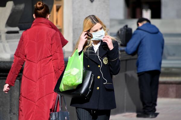 Жительница Минска идет по улице в защитной маске - Sputnik Беларусь