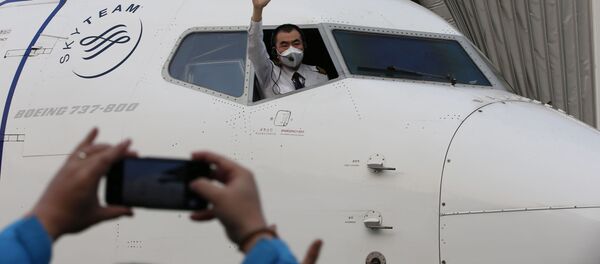 Пилот машет из окна кабины, перед тем, как рейс вылетит из международного аэропорта Ухань  - Sputnik Беларусь