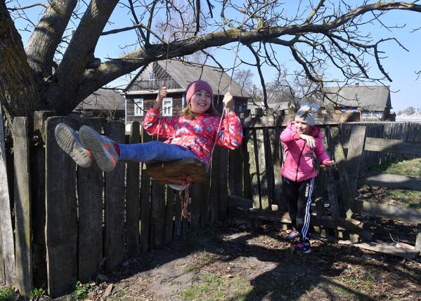 Дети на качелях у дома в деревне - Sputnik Беларусь