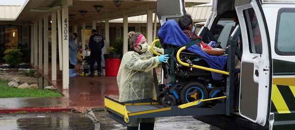 Медицинский работник в защитном костюме и пациент во время пандемии коронавируса - Sputnik Беларусь