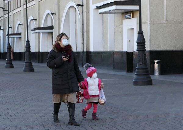 Женщина с ребенком в защитных масках на железнодорожном вокзале в Киеве, Украина - Sputnik Беларусь