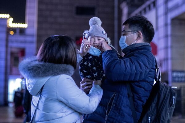 Родители надевают защитную маску на своего ребенка в Пекине - Sputnik Беларусь