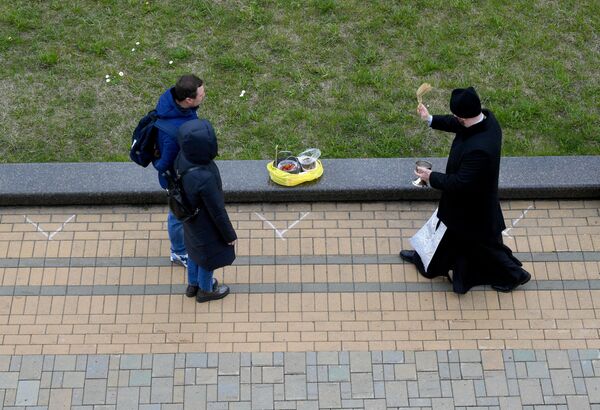Верующие соблюдали социальное дистанцирование - для них специально на тротуаре нарировали знаки для расположения. - Sputnik Беларусь