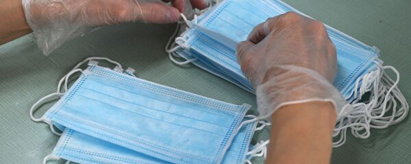 Сотрудница аптеки фасует одноразовые медицинские маски в упаковки - Sputnik Беларусь