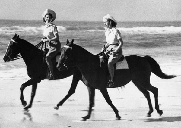 В 1947 году Елизавета сопровождала родителей в поездке по Южной Африке. Прогулка на лошадях с сестрой по побережью. - Sputnik Беларусь