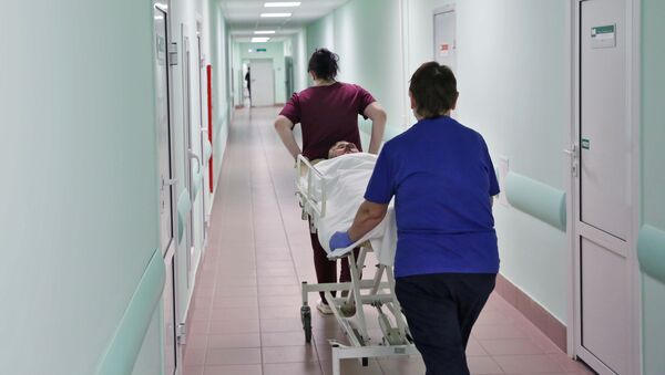 Медсестры везут каталку с больным по коридору в больнице, архивное фото - Sputnik Беларусь
